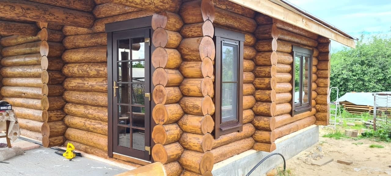 Готовый вход в дом из бревна с деревянной дверью